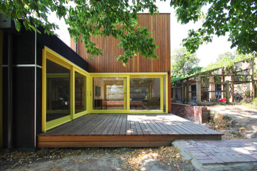 Imagen de fachada beige actual grande de dos plantas con revestimiento de madera