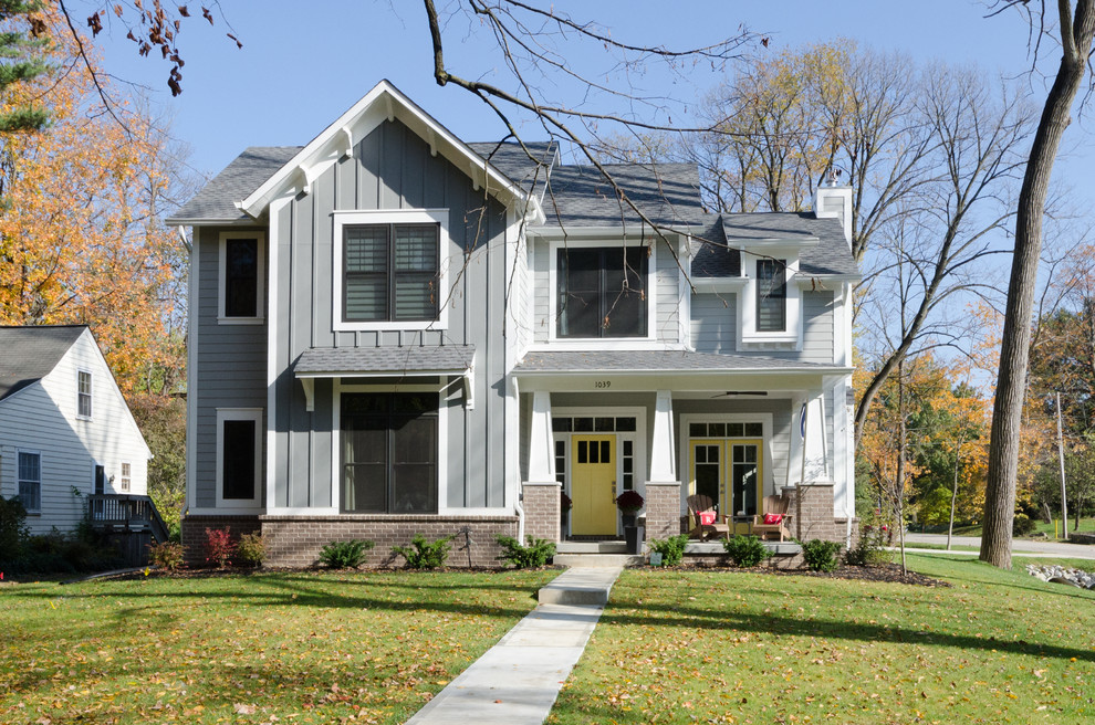 Ejemplo de fachada de casa gris de estilo americano de dos plantas con revestimiento de vinilo y tejado a dos aguas