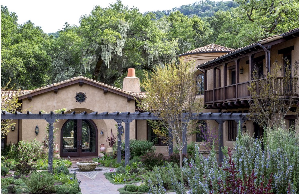 Inspiration for a large mediterranean beige two-story stucco exterior home remodel in Denver with a tile roof