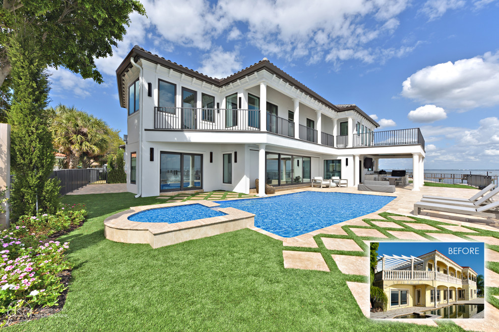 This is an example of a large and white mediterranean two floor render detached house with a hip roof and a tiled roof.
