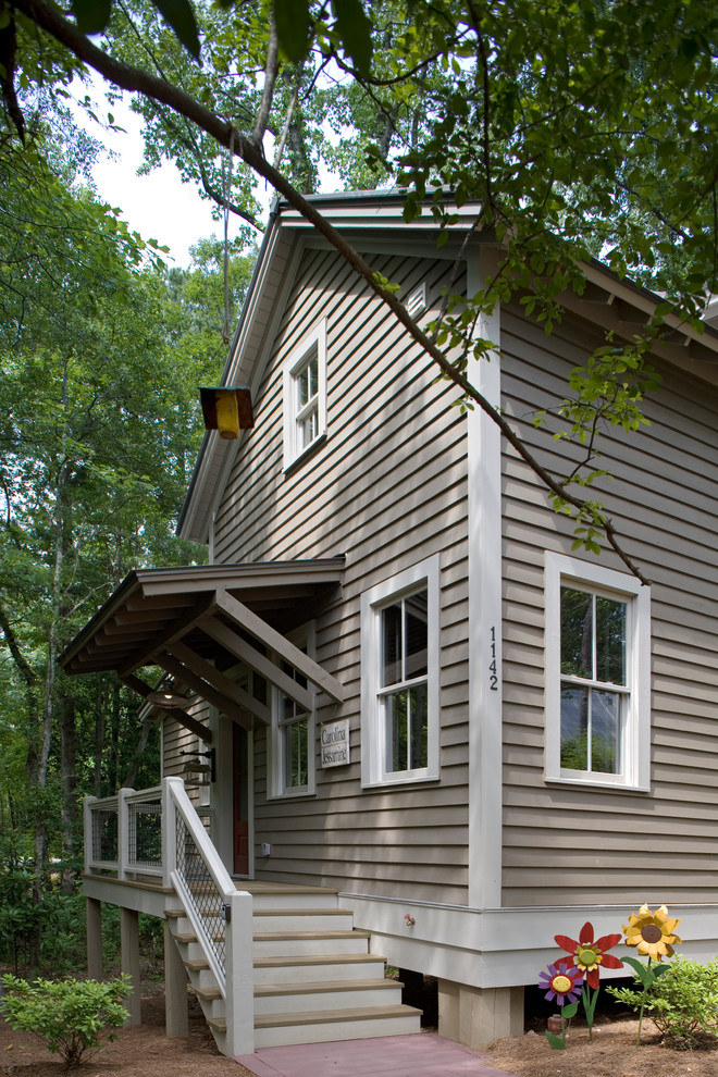Exempel på ett rustikt grått hus, med två våningar