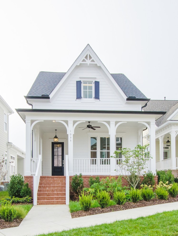 Cette photo montre une façade de maison blanche chic de plain-pied avec un toit à deux pans et un toit en shingle.