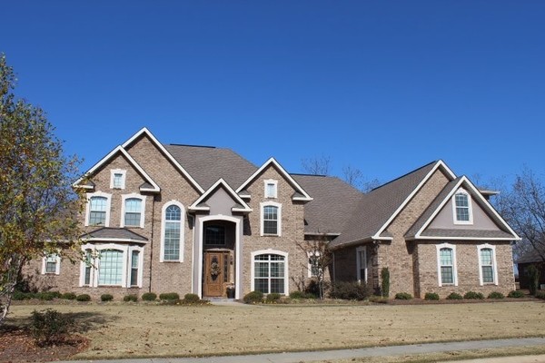 Photo of a large and beige classic two floor brick house exterior in Atlanta with a hip roof.