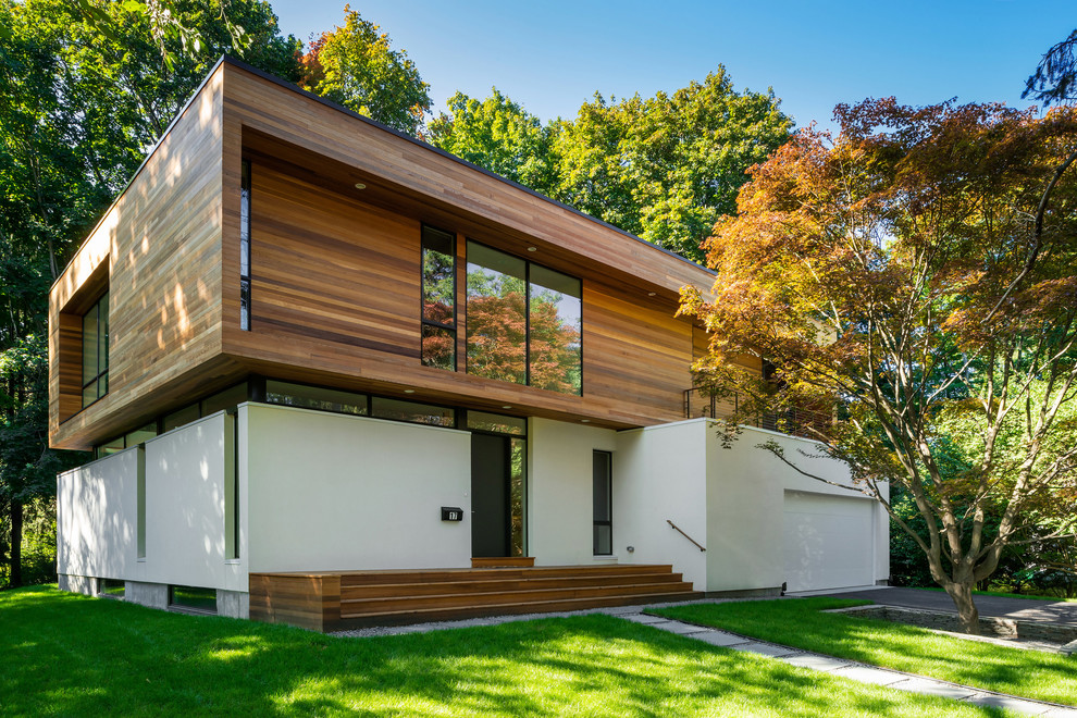 Ejemplo de fachada blanca minimalista grande de dos plantas con revestimiento de madera y tejado plano