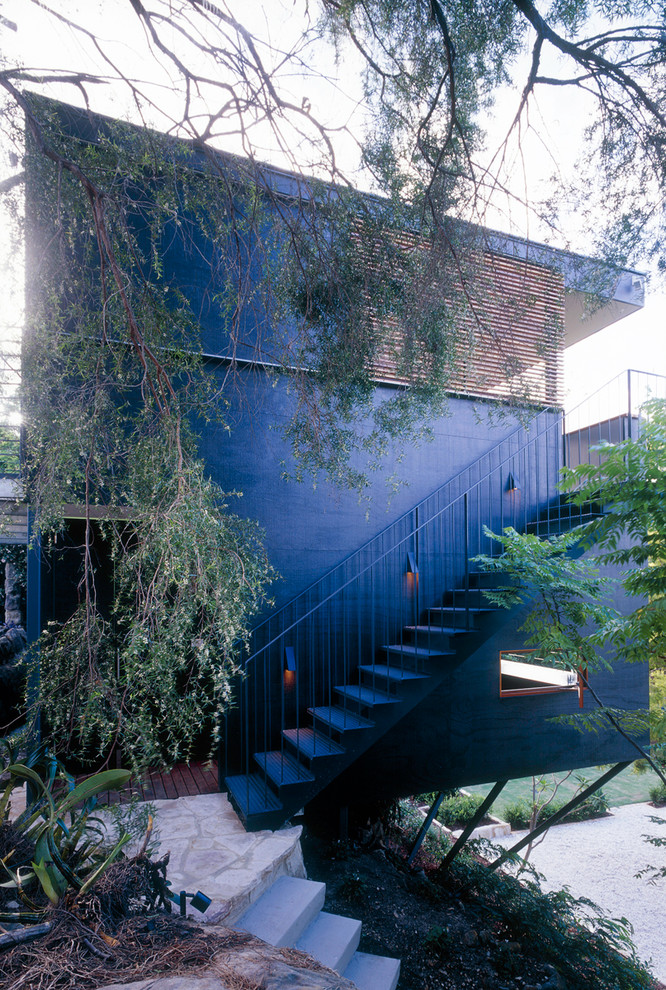 Imagen de fachada negra contemporánea pequeña de dos plantas con revestimiento de madera y tejado plano