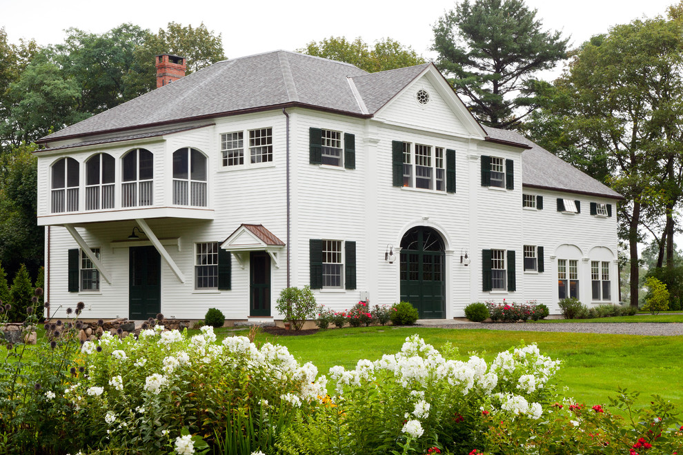 Esempio della facciata di una casa bianca classica a due piani con rivestimento in legno e tetto a padiglione