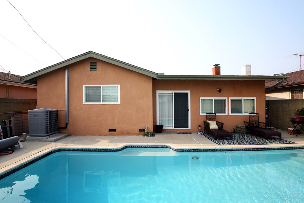 Mittelgroßes, Einstöckiges Uriges Einfamilienhaus mit Putzfassade, oranger Fassadenfarbe, Satteldach und Schindeldach in Los Angeles