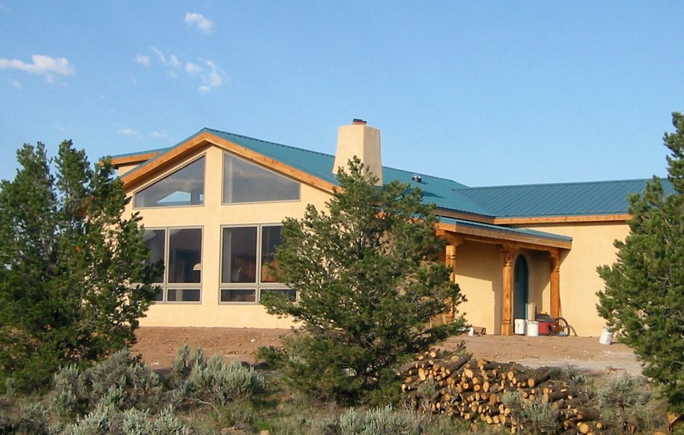 Mittelgroßes, Einstöckiges Eklektisches Haus mit Putzfassade, gelber Fassadenfarbe und Satteldach in Albuquerque