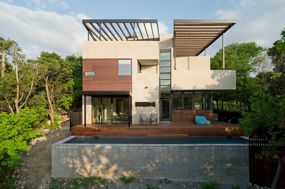 Стильный дизайн: двухэтажный, бежевый частный загородный дом в современном стиле с комбинированной облицовкой и плоской крышей - последний тренд