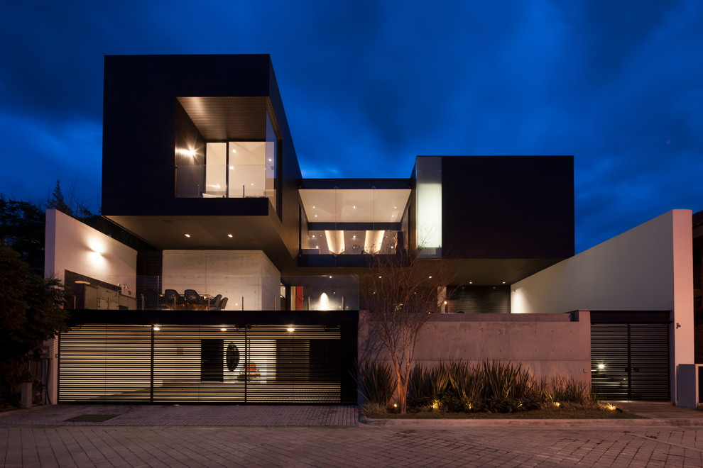 Réalisation d'une façade de maison noire design à deux étages et plus.