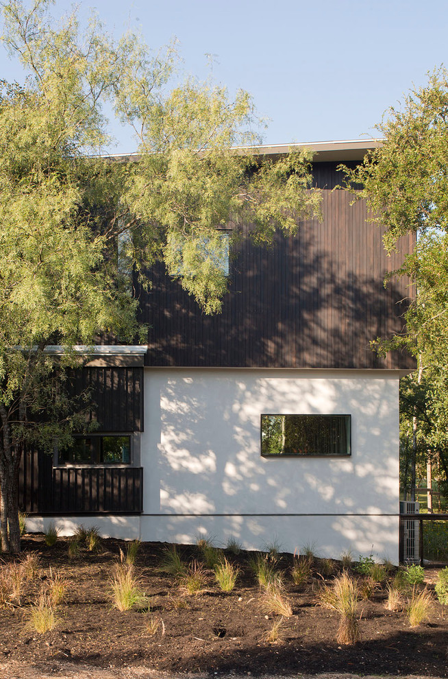 Photo of a small and white contemporary two floor house exterior in Austin with wood cladding and a flat roof.