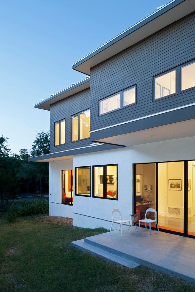 Esempio della facciata di una casa piccola bianca contemporanea a due piani con rivestimento in legno e tetto piano