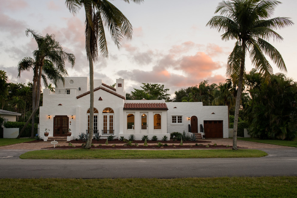 Zweistöckiges Mediterranes Einfamilienhaus mit weißer Fassadenfarbe, Flachdach und Ziegeldach in Miami