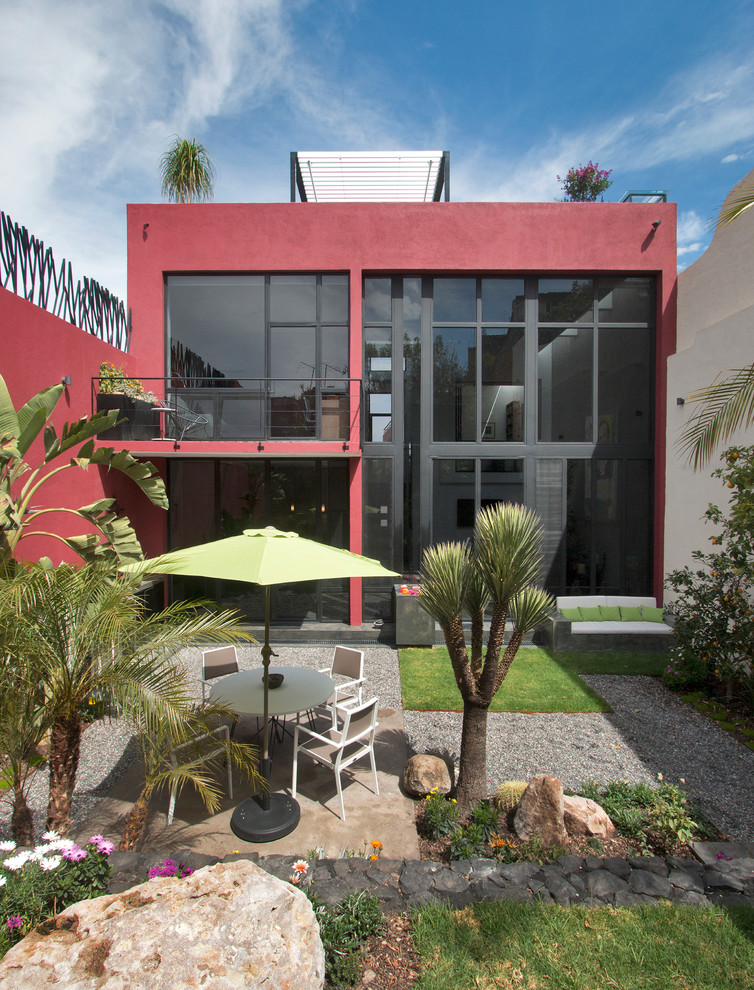 Foto della facciata di una casa piccola rossa moderna a due piani con rivestimento in stucco e tetto piano