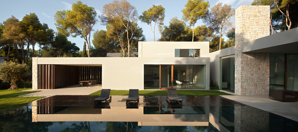Beige and large modern two floor concrete house exterior in Valencia with a flat roof.