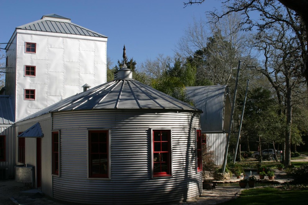 Ejemplo de fachada de casa gris campestre grande de dos plantas con revestimiento de metal, tejado a dos aguas y tejado de metal