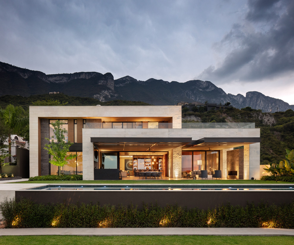Diseño de fachada de casa beige actual grande de dos plantas con revestimientos combinados y tejado plano