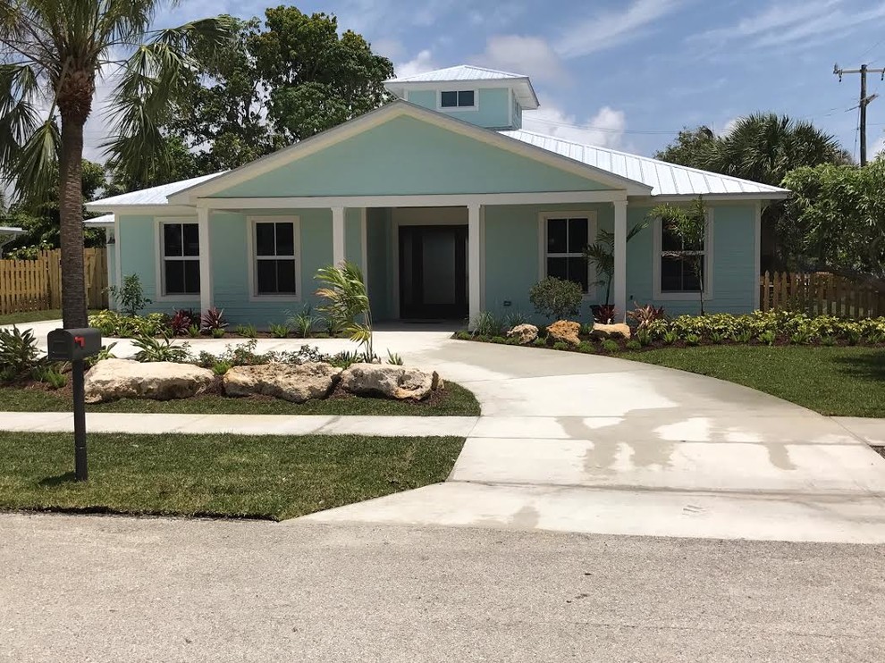 This is an example of a medium sized and blue coastal bungalow detached house in Miami with vinyl cladding, a hip roof and a metal roof.