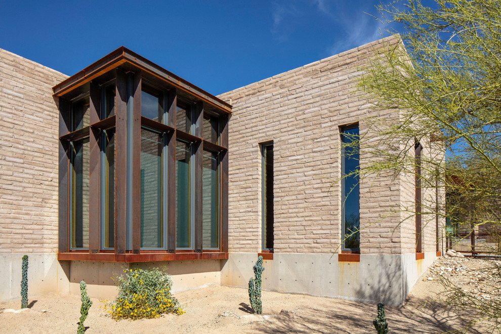 Diseño de fachada de casa de estilo americano de una planta con revestimiento de adobe