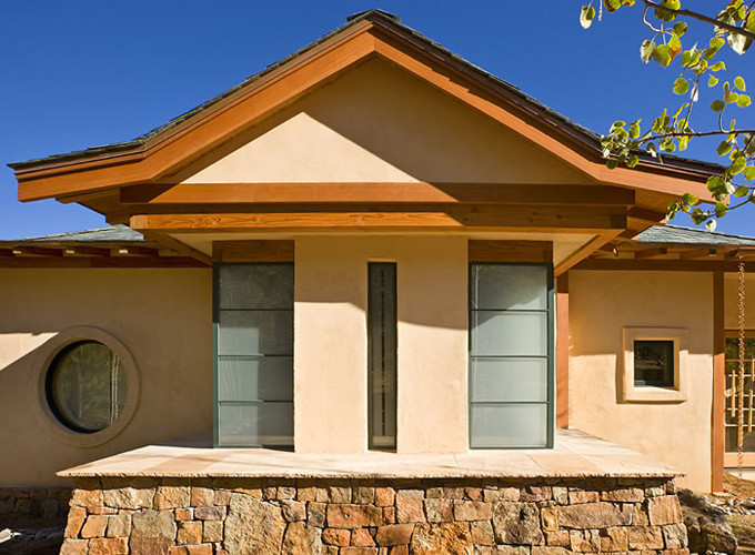 Diseño de fachada de casa beige asiática grande de una planta con revestimiento de estuco, tejado a cuatro aguas y tejado de teja de madera