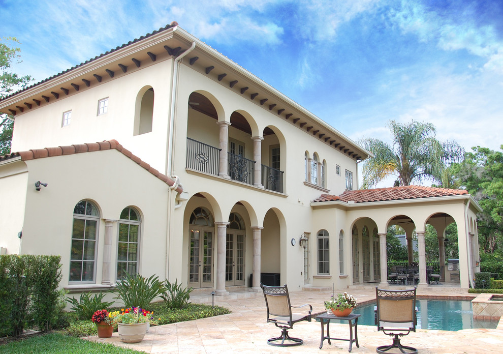 Large tuscan yellow two-story stucco exterior home photo in Orlando