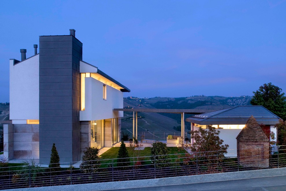 Exemple d'une façade de maison blanche tendance à deux étages et plus avec un toit à quatre pans.