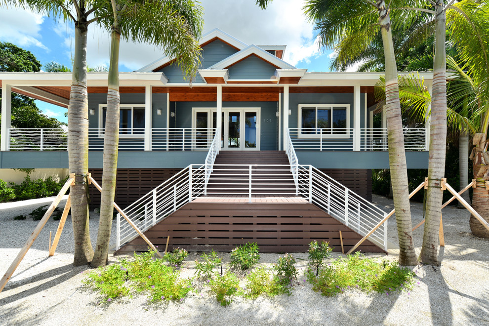 Diseño de fachada de casa azul marinera grande de dos plantas con revestimiento de vinilo, tejado a cuatro aguas y tejado de metal