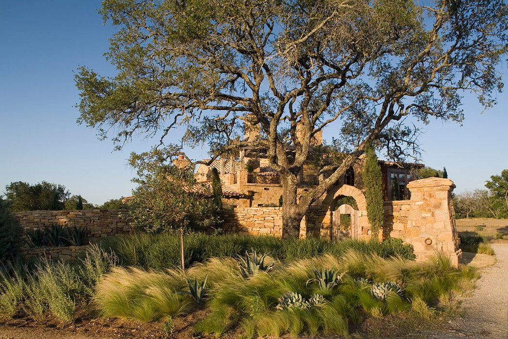 Example of a tuscan stone exterior home design in Austin