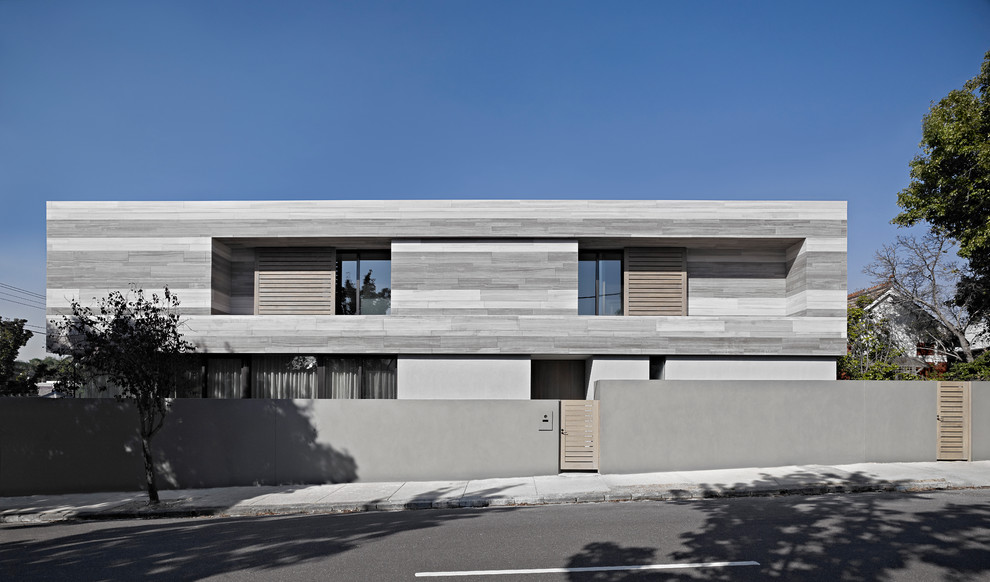 Modelo de fachada gris minimalista grande de dos plantas con revestimiento de piedra y tejado plano