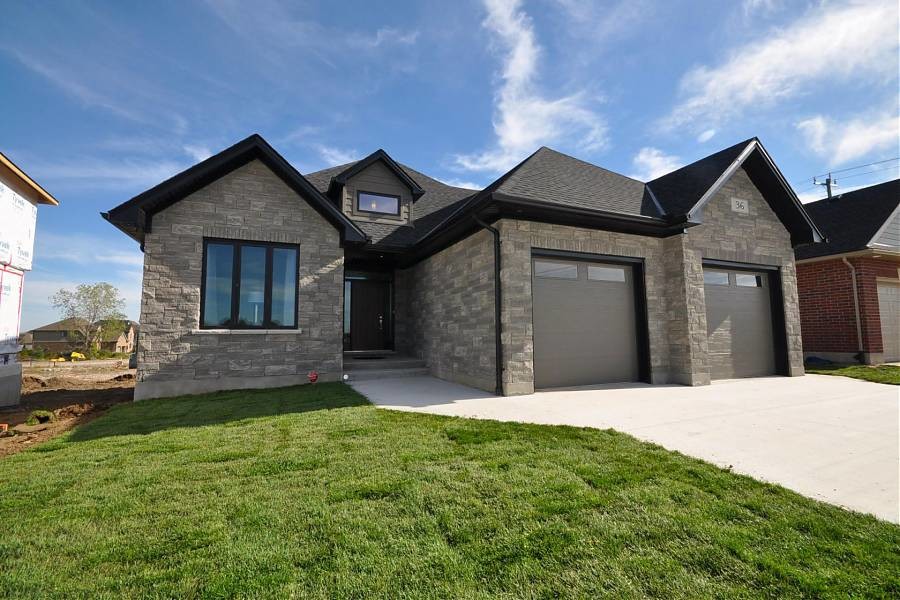 Mid-sized trendy gray one-story stone house exterior photo in Toronto with a hip roof and a shingle roof