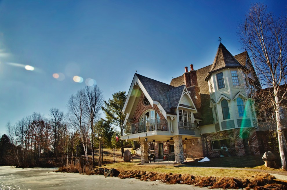Exemple d'une grande façade de maison multicolore montagne à deux étages et plus avec un revêtement mixte, un toit à deux pans et un toit en shingle.