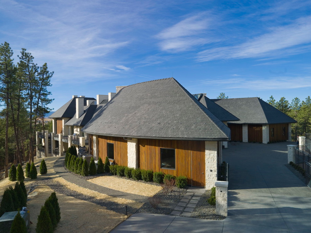 Foto de fachada de casa beige actual grande de tres plantas con revestimiento de piedra, tejado a cuatro aguas y tejado de teja de madera