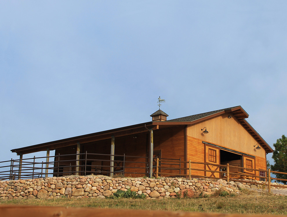 Immagine della facciata di una casa grande rustica a un piano con rivestimento in legno e tetto a capanna