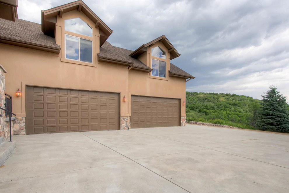 Large mountain style beige two-story stucco exterior home photo in Denver