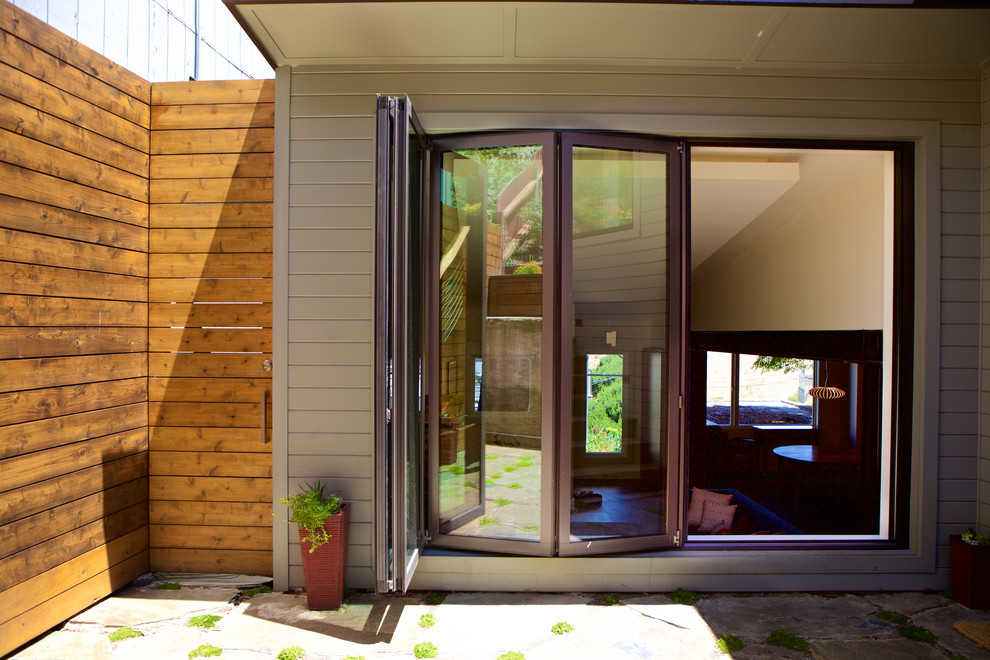 Aménagement d'une grande façade de maison verte moderne en bois à un étage avec un toit à quatre pans et un toit en shingle.