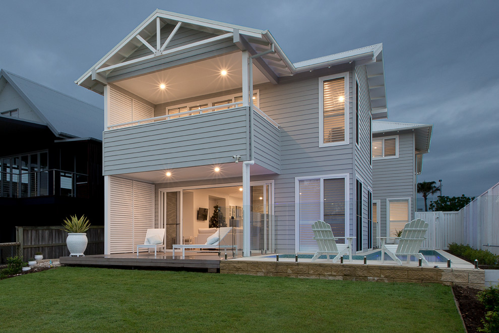 This is an example of a gey coastal two floor house exterior in Gold Coast - Tweed with wood cladding.