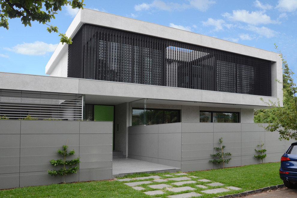 Пример оригинального дизайна: большой, двухэтажный, серый дом в стиле модернизм с облицовкой из бетона и плоской крышей
