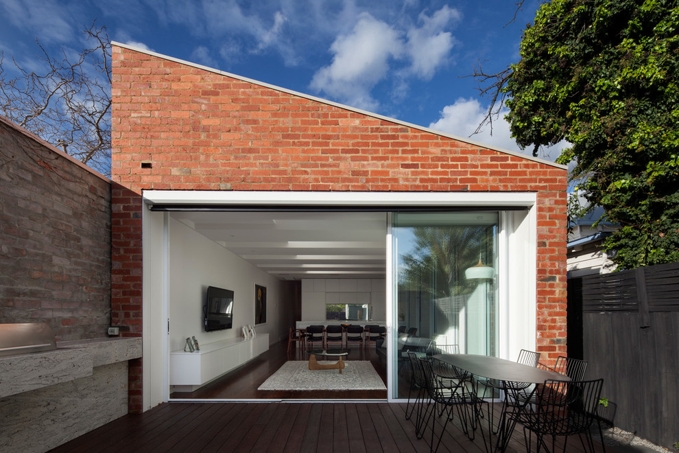 Design ideas for a red contemporary bungalow brick house exterior in Melbourne with a lean-to roof.