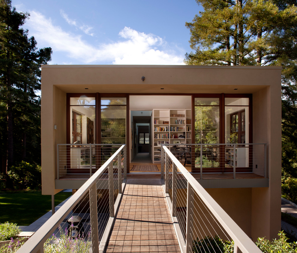 Réalisation d'une façade de maison marron minimaliste en stuc de taille moyenne et à un étage avec un toit plat.