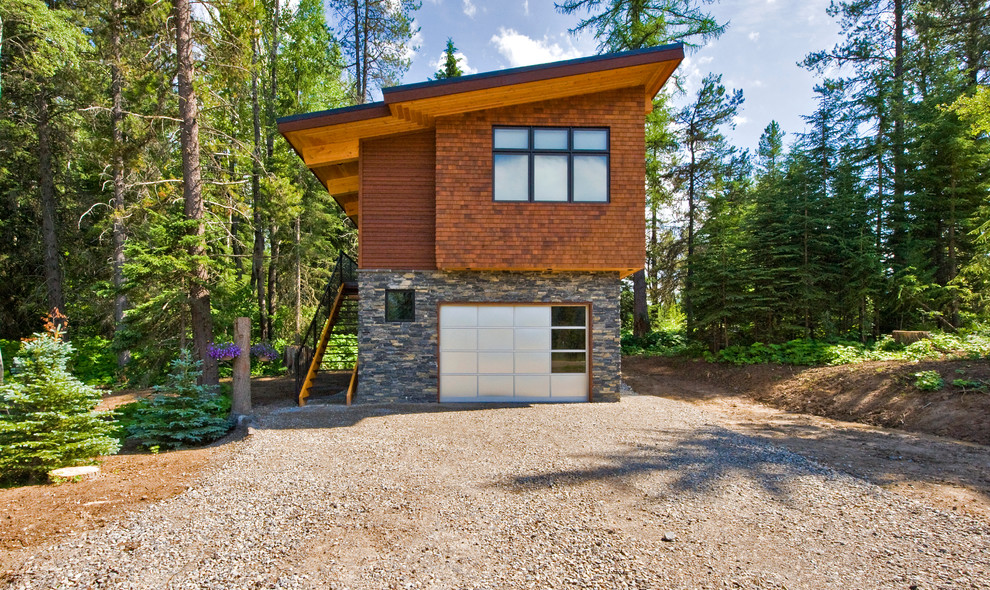Inspiration for a contemporary house exterior in Calgary with wood cladding and a lean-to roof.