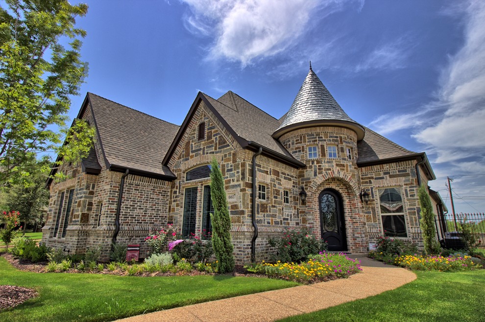 Example of a huge ornate brown two-story brick house exterior design in Dallas with a shingle roof
