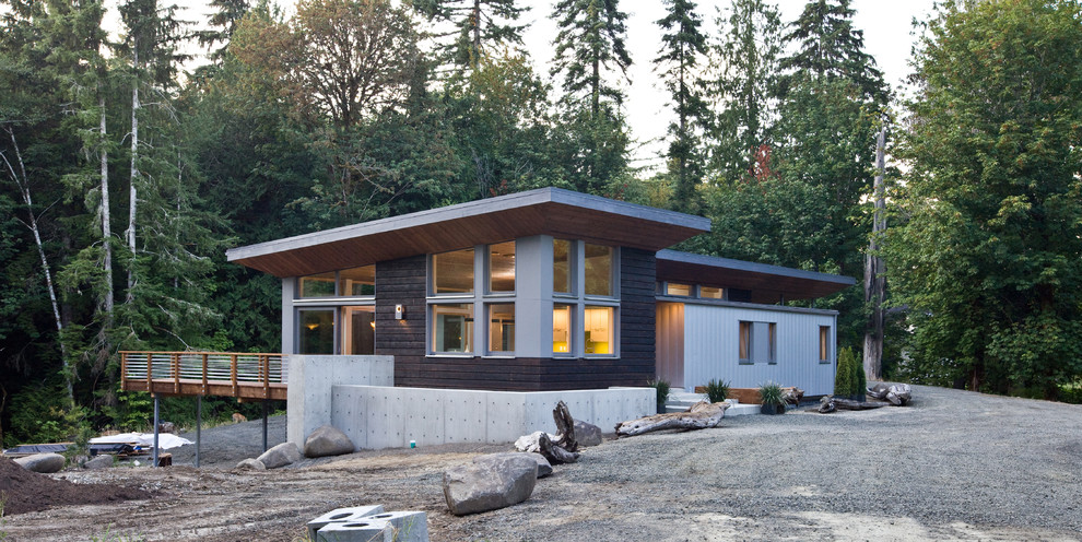 Diseño de fachada de casa marrón moderna grande de una planta con revestimiento de madera y tejado de un solo tendido