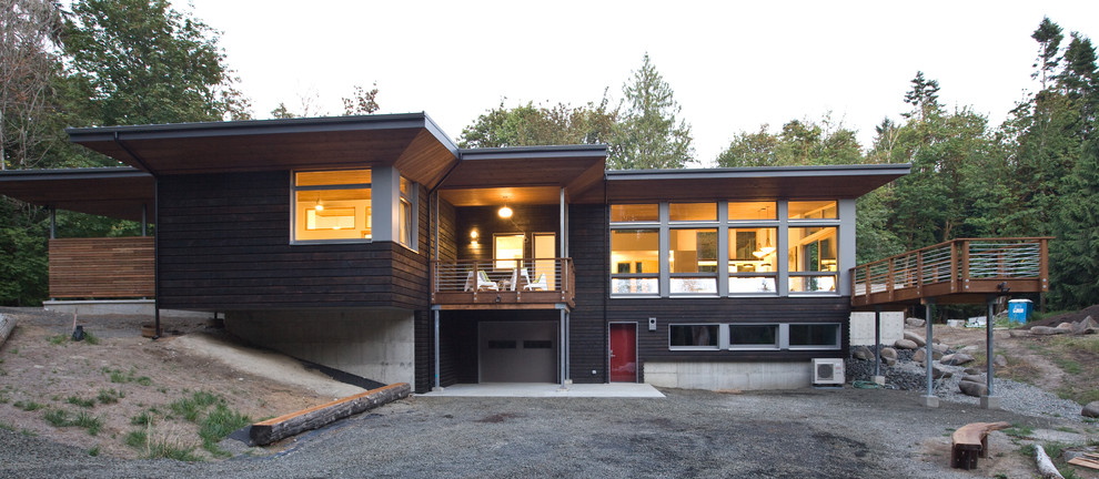 Foto de fachada de casa marrón moderna grande de una planta con revestimiento de madera y tejado de un solo tendido