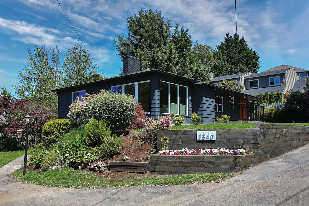 Imagen de fachada de casa gris retro grande de dos plantas con revestimiento de madera, tejado a cuatro aguas y tejado de teja de madera
