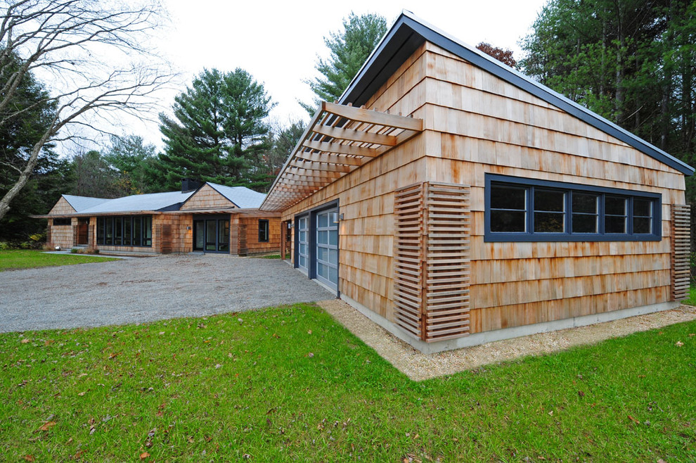 Medium sized and brown modern bungalow house exterior in Boston with wood cladding and a flat roof.