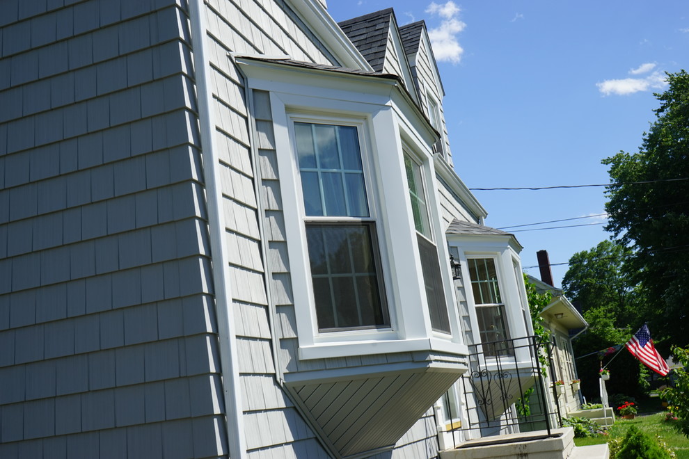 Idées déco pour une petite façade de maison grise rétro à un étage avec un revêtement en vinyle et un toit à deux pans.