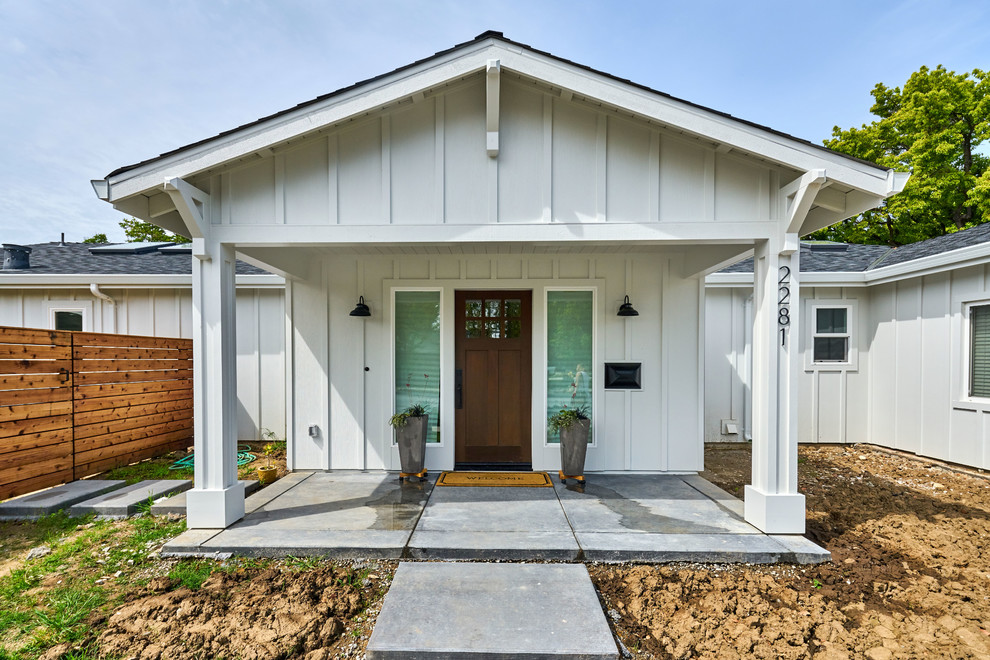 Ejemplo de fachada de casa blanca de estilo de casa de campo de una planta con revestimiento de madera, tejado a dos aguas y tejado de teja de madera