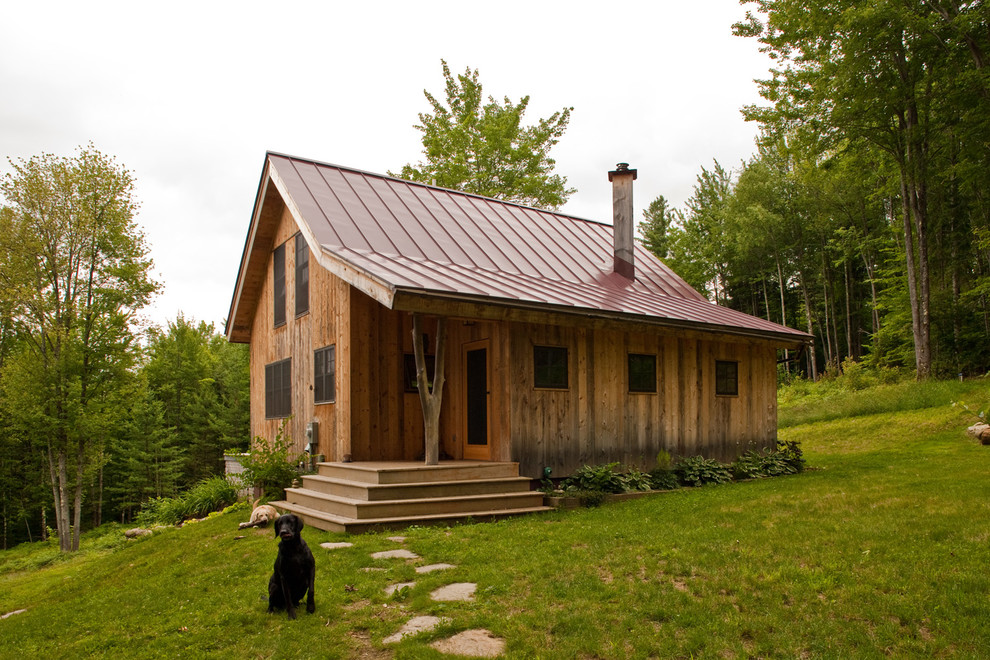 Immagine della facciata di una casa piccola rustica a due piani con rivestimento in legno e tetto a capanna