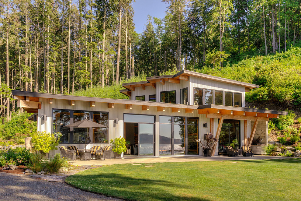 Photo of a contemporary two floor house exterior in Vancouver with metal cladding and a lean-to roof.