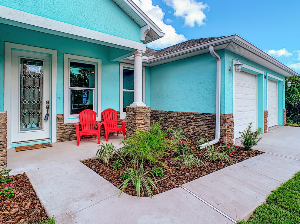 Mid-sized elegant blue one-story stucco house exterior photo in Orlando with a clipped gable roof and a shingle roof